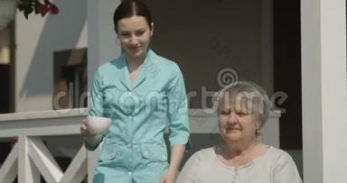 在红镜头拍摄的阳光明媚的日子里，养老院护理员为快乐的养老金领取者一起笑一杯咖啡
